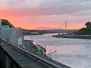 a view of a river at sunset with a bridge at City centre Rooftop apartment alongside river Suir in Waterford