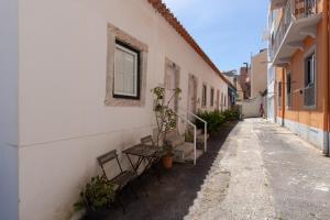 an alley with benches and a window on the side of a building at Classic Lisbon Homes: Bright & Central in Belém in Lisbon