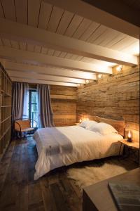 a bedroom with a large bed and a wooden wall at Domaine du Kaegy - Hébergements 5 étoiles in Steinbrunn-le-Bas