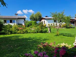 un cortile con una casa e dei fiori di Bungalows Raschun Grabelsdorf Etruskerweg 10 A-9122 St.Kanzian a Grabelsdorf