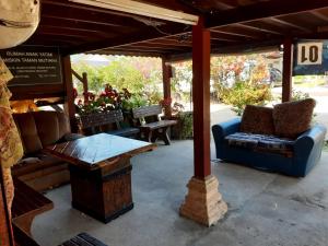 eine überdachte Terrasse mit einem Sofa und einem Tisch in der Unterkunft Homestay Teratak Kayu kota Aur in Kepala Batas