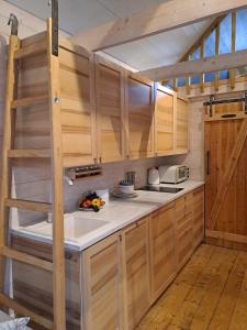 una cocina con armarios de madera y una escalera en Bursztynowe Domki w Helu, en Hel