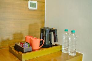 古爾岡的住宿－古茹格拉姆市中心萬怡酒店，一个带咖啡壶和两瓶水的托盘