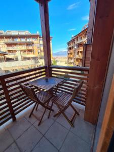einen Tisch und einen Stuhl auf einem Balkon mit Aussicht in der Unterkunft Four Seasons Apartment Bansko in Bansko
