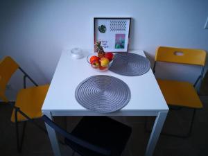 - une table blanche avec un bol de fruits dans l'établissement Zentrum, helle und ruhige möblierte DG-Wohnung zwischen Steintor und Uni, à Hanovre