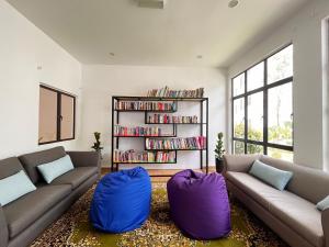 a living room with two couches and a book shelf at ēRYA by SURIA Hot Spring Bentong in Bentong