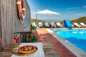 a table with a cake and a glass of wine next to a pool at 21 Sleeps Private Pool Villa & BBQ Near Barcelona in Rocafort