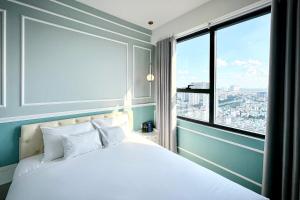 a bedroom with a white bed with a large window at Yu Stay Apartment in Soho D1 near Bui Vien walking street in Ho Chi Minh City