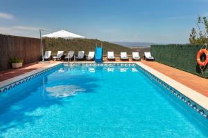 a swimming pool with chairs and blue water at 21 Sleeps Private Pool Villa & BBQ Near Barcelona in Rocafort