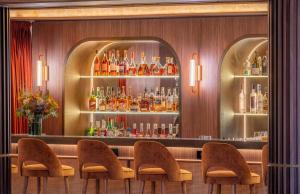 a bar with a bunch of bottles of alcohol at Hôtel Burdigala by Inwood Hotels in Bordeaux