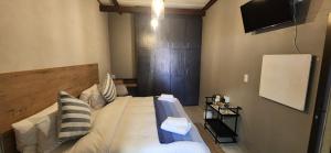 1 dormitorio con 1 cama grande y cabecero de madera en Livingwaters Self-Catering Accommodation, en Ermelo