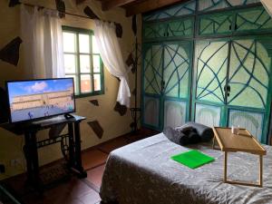 a bedroom with a computer on a bed and a window at CASA RURAL CANARIA HOMBRE DE PALO in Santa Cruz de Tenerife