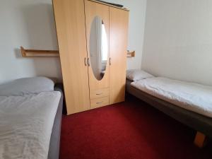 een kamer met 2 bedden en een kast met een spiegel bij Harzblick 13 in Hahnenklee-Bockswiese