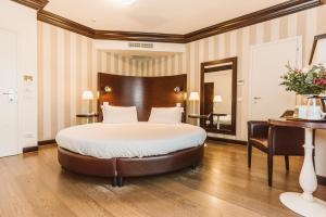 a hotel room with a large bed and a desk at Palazzo Bezzi Hotel in Ravenna