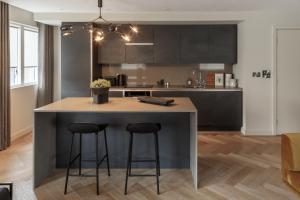 a kitchen with a large island with two bar stools at 9 Kings, Hudson Quarters- FREE PARKING in York