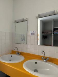 łazienka z 2 umywalkami i lustrem w obiekcie Auberge de jeunesse HI Poitiers w mieście Poitiers