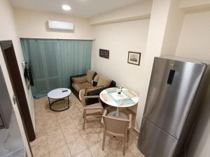 a living room with a refrigerator and a table at Athens Sky Suites 1 in Piraeus