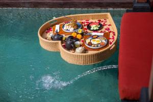 un pequeño bote de juguete flotando en el agua en Nyanyi Sanctuary Villa by Ini Vie Hospitality, en Tanah Lot