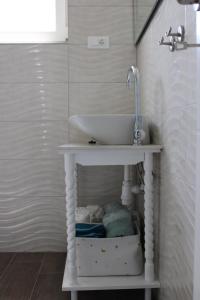 baño con lavabo blanco sobre una mesa en Apartman Maslina, en Šibenik