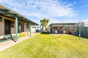 a backyard of a house with a grass yard at Cables Beach House Lancelin in Lancelin