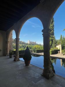 an archway with a view of a pond at Hostal Juan Bravo in Segovia