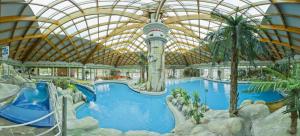 a large pool in a resort with a domed ceiling at Počitniška hišica Patrik Terme Čatež in Mostec