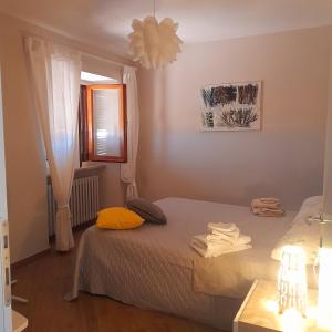 een kleine slaapkamer met een bed en een raam bij Atelier di Denise in Panicale
