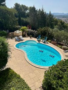 una piscina con tumbonas y una piscina en Les Amandiers, en Draguignan