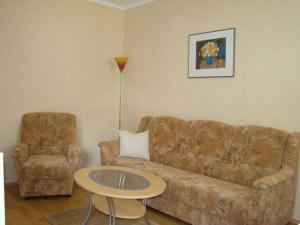 ein Wohnzimmer mit einer Couch und einem Tisch und einem Stuhl in der Unterkunft Ferienwohnungen Mülling in Heringsdorf