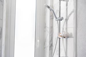 - Baño con cabezal de ducha junto a una ventana en [Twins apartament Giallo]clima en Génova