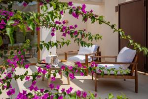 een patio met stoelen en paarse bloemen bij Can Lluc Hotel Rural in Sant Rafael de Sa Creu