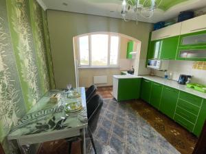 a kitchen with green cabinets and a table with chairs at Quiet appartment in Bishkek city in Bishkek +16 photos