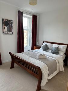 um quarto com uma cama grande e uma janela em Comfy Two Bedroom Apartment Right In The City Centre em Glasgow