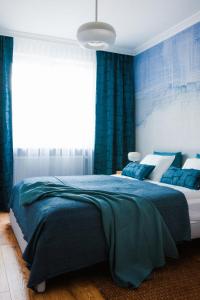 a bedroom with a large bed with blue curtains at Apartamenty Blue in Biała Podlaska