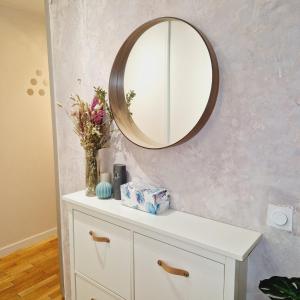 uma cómoda branca com um espelho na parede em Modern and confortable apartment close to Paris em Bois-Colombes