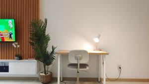 uma secretária com uma cadeira, um candeeiro e uma planta em Perfect Rating Nexflix Jaya One Mall Seksyen 13 PJ em Petaling Jaya