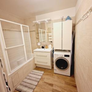 uma pequena casa de banho com uma máquina de lavar roupa e um lavatório em Modern and confortable apartment close to Paris em Bois-Colombes