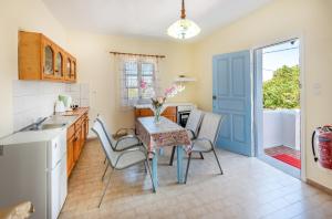 a kitchen with a table and chairs and a kitchen with a door at Giannis apartment in Kalymnos