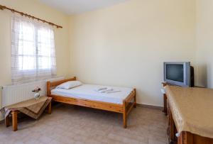 a small room with a bed and a tv at Giannis apartment in Kalymnos