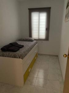 een kleine slaapkamer met een bed en een raam bij Apartamento Marlayo in Cala Blanca