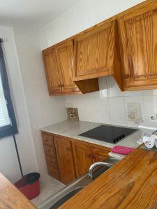 een keuken met houten kasten en een wastafel bij Apartamento Marlayo in Cala Blanca