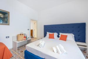 1 dormitorio con 1 cama grande con almohadas de color naranja en YourHome - Casa Vittoria, en Meta