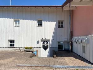 a white barn with a white door and a building at Haus Seerose in Taching am See