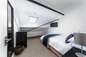 a attic bedroom with a bed and a staircase at McLaren House Seahouses in Seahouses