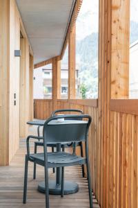 2 Stühle und ein Tisch auf einer Veranda in der Unterkunft Casa Flurina in Flims