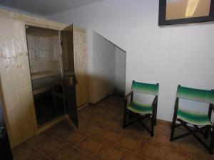 Agriturismo Soiano Famiglia Rolfini في مونتايون: غرفة بها كرسيين وخزانة ملابس