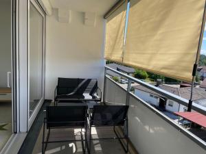 2 Stühle auf einem Balkon mit Fenster in der Unterkunft Guck zum Bodensee in Uhldingen-Mühlhofen