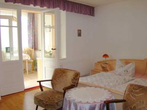 ein Schlafzimmer mit einem Bett und zwei Stühlen und einem Tisch in der Unterkunft Ferienwohnungen Mülling in Heringsdorf