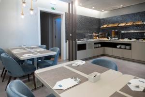 a restaurant with tables and chairs and a kitchen at AMMA Lisboa Hotel in Lisbon