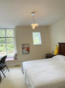 sypialnia z białym łóżkiem i oknem w obiekcie Derbyshire House w mieście Coquitlam